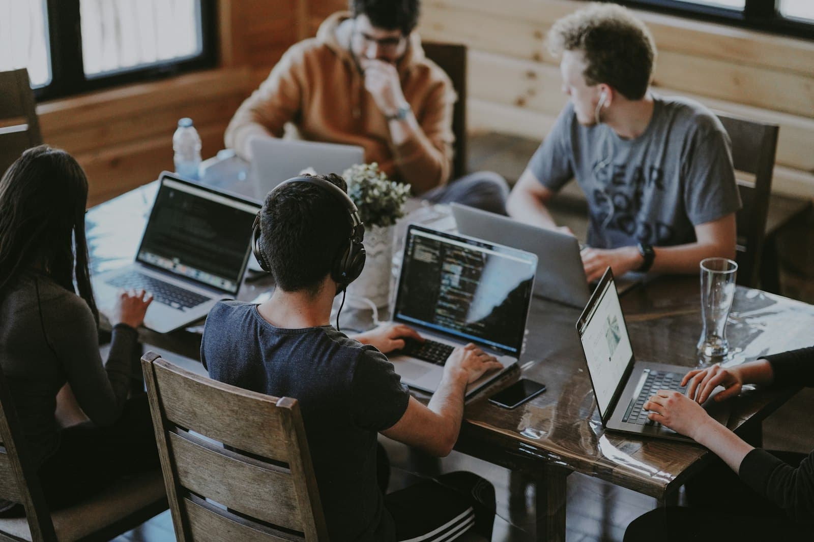 Professionals collaborating around a laptop in a bright modern workspace